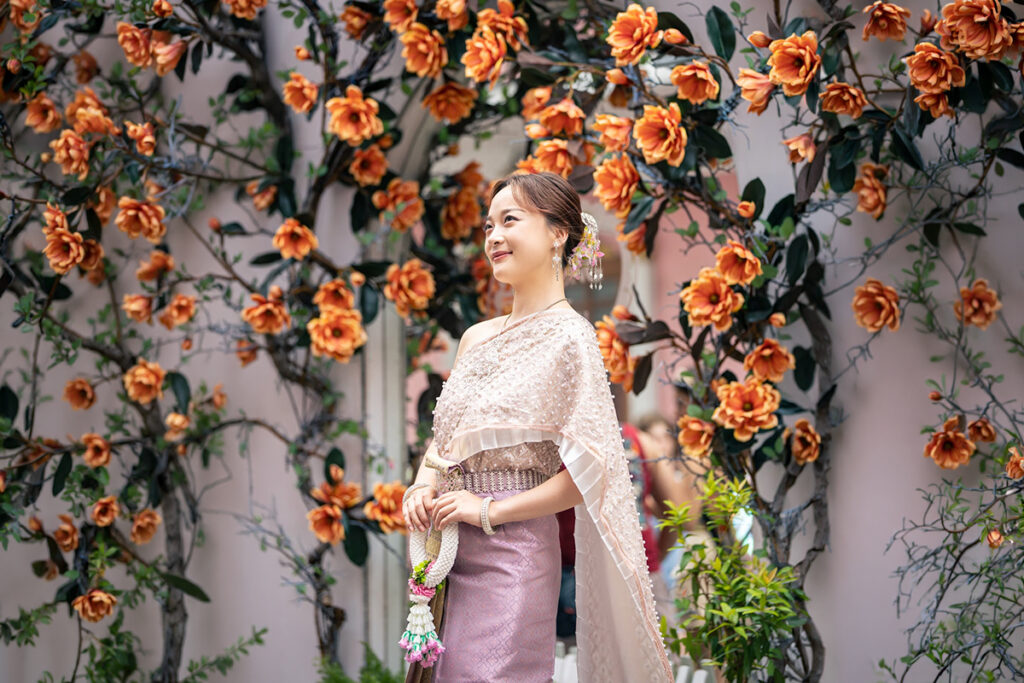 タイ衣装を着て、シノポルトギース様式の建物が並ぶプーケット・オールドタウンを歩く女性